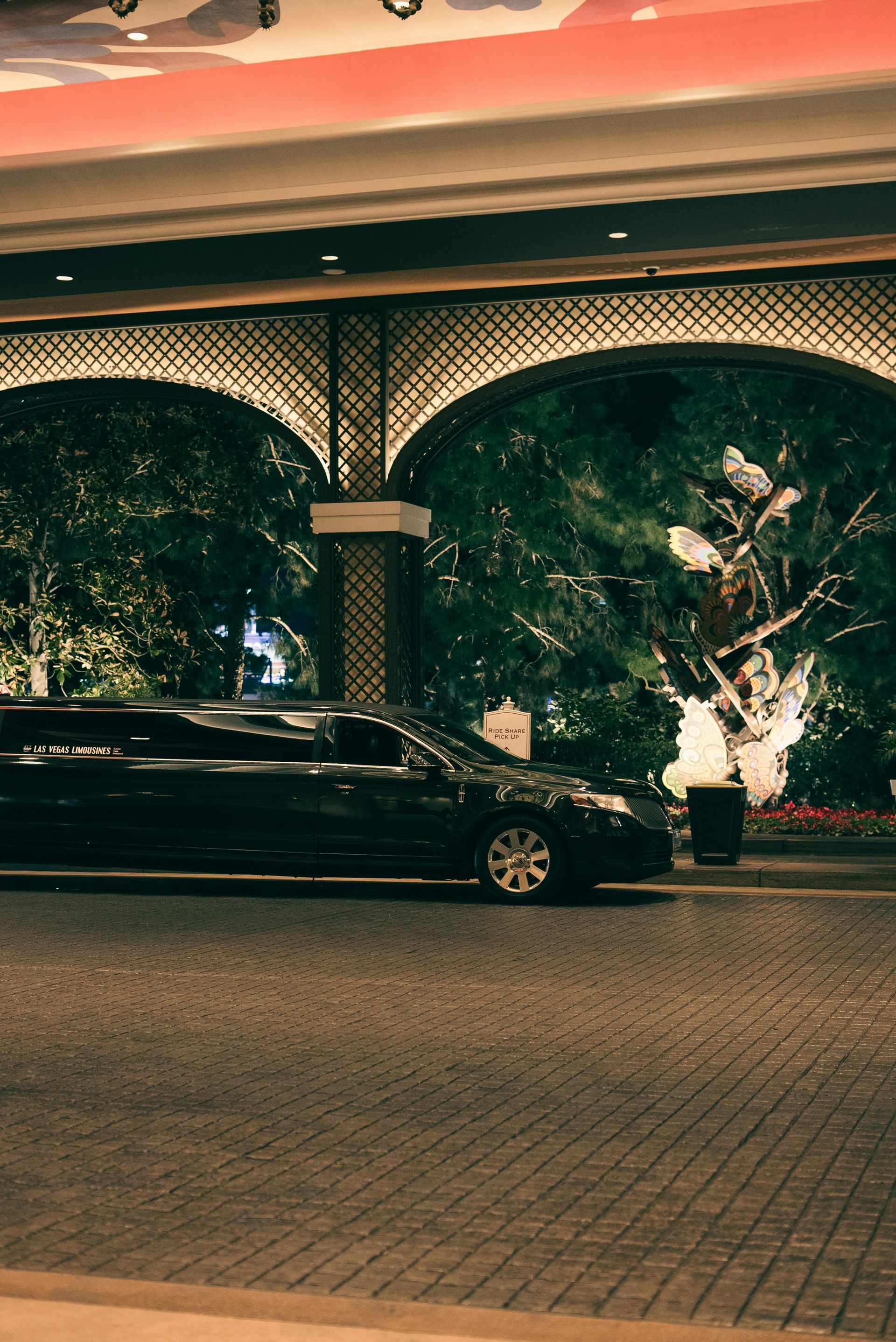 A black limousine parked outside an ornate building entrance.