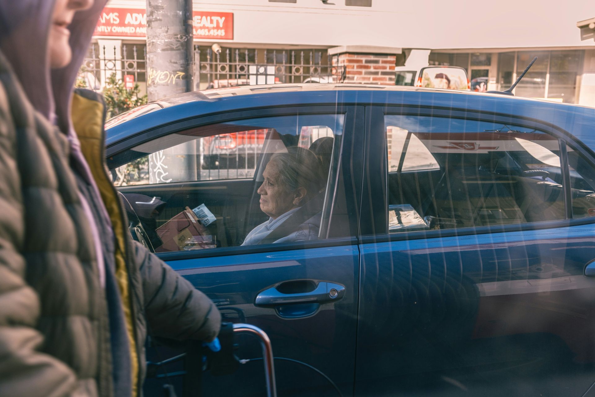Woman in car looking out window at street